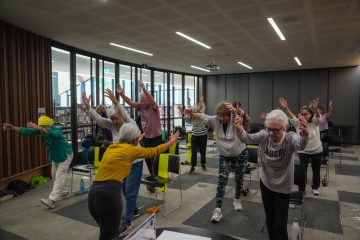 Older people participating in a chair Pilates class