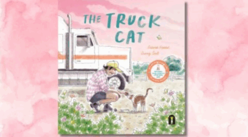 Illustrated book cover of The Truck Cat shows a person in a cap and plaid shirt kneeling to pet an orange and white cat. A large white truck and pink flowers are in the background, with a soft pink watercolor backdrop.