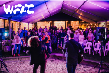 Two musicians perform on stage under a tent at night facing an audience seated and standing. Colorful lights illuminate the scene. Walyalup Fremantle Arts Centre logo appears in the top left corner.