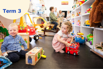 Two young children play with toys on the floor of a colorful playroom, surrounded by various toys and shelves, while several adults sit and talk in the background. The text Term 3 is displayed in a circle in the top left corner.