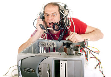 A frustrated man with tangled computer cables on his head shouts into a phone while working on an open desktop computer case, expressing stress or confusion with technology.