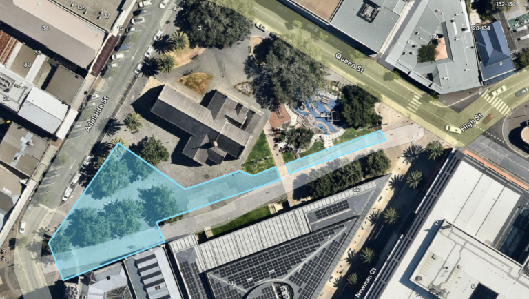 Aerial view of an urban area showing streets, buildings, trees, and a highlighted blue section covering part of a plaza and pathway near the intersection of Adelaide Street, Queen Street, and Eagle Street.