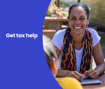 A woman smiles while sitting at a table outdoors. Text on a blue background reads, Get tax help.