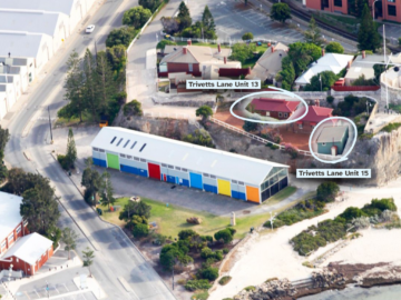 Aerial view of a coastal area with colorful buildings; two houses labeled Trivetts Lane Unit 13 and Trivetts Lane Unit 15 are circled, surrounded by trees, parking lots, and nearby beaches.